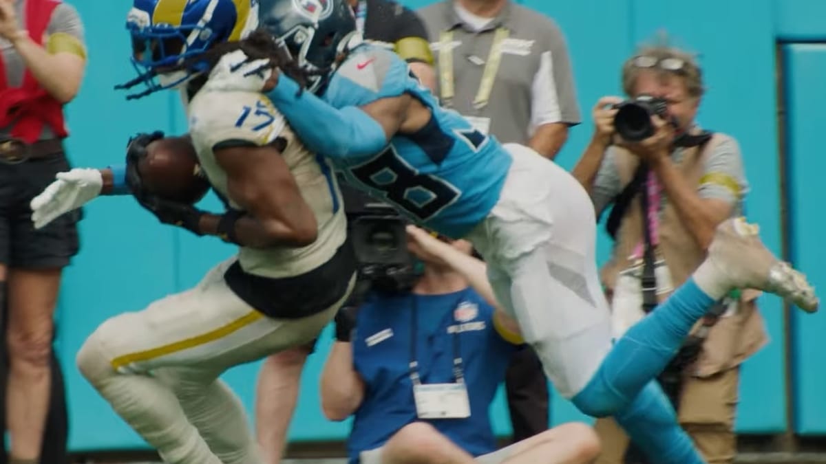 Davante Adams carries the football for the Los Angeles Rams while being tackled by the Tennessee Titans.