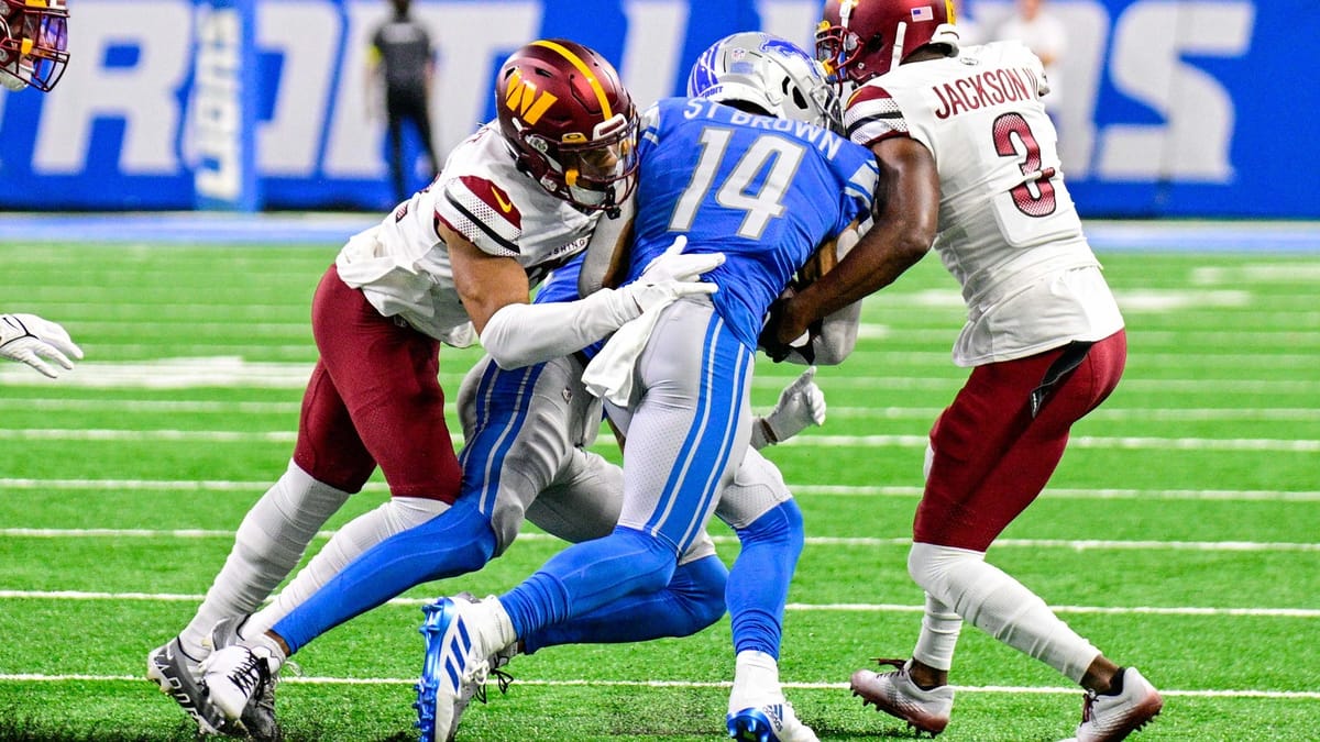 Amon-Ra St. Brown carries the football for the Detroit Lions against the Washington Commanders.